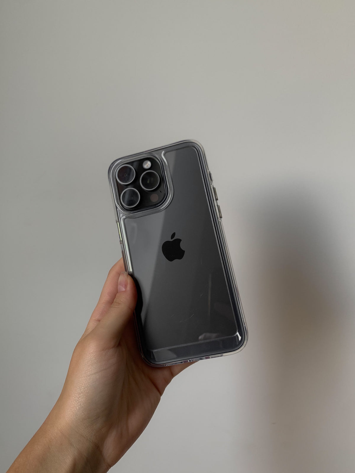 Чохол «Металеві деталі» на темному iPhone у руці, крізь чохол видно логотип Apple