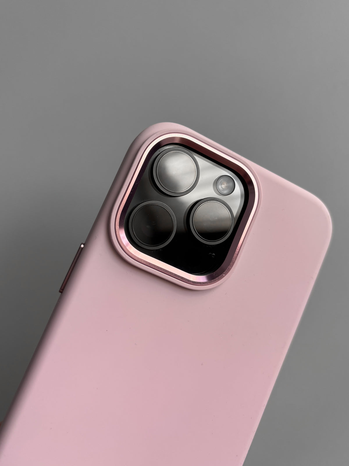 Рожевий чохол для iPhone — крупний план рожевої металевої рамки навколо камер
