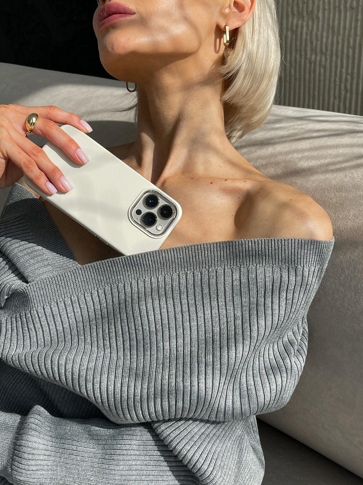 Жінка тримає біля плеча iPhone у молочному чохлі «Металеві деталі»