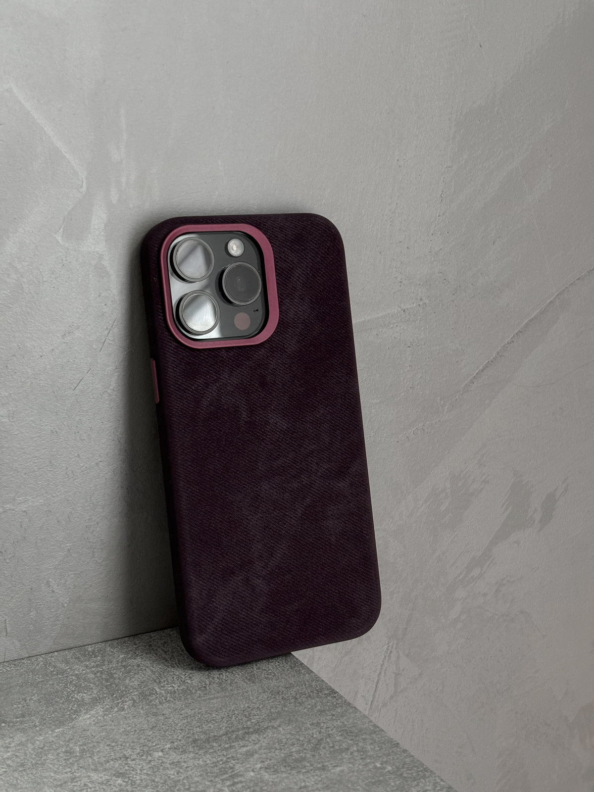 Чохол «Замшева м’якість» на iPhone стоїть біля бетонної стіни