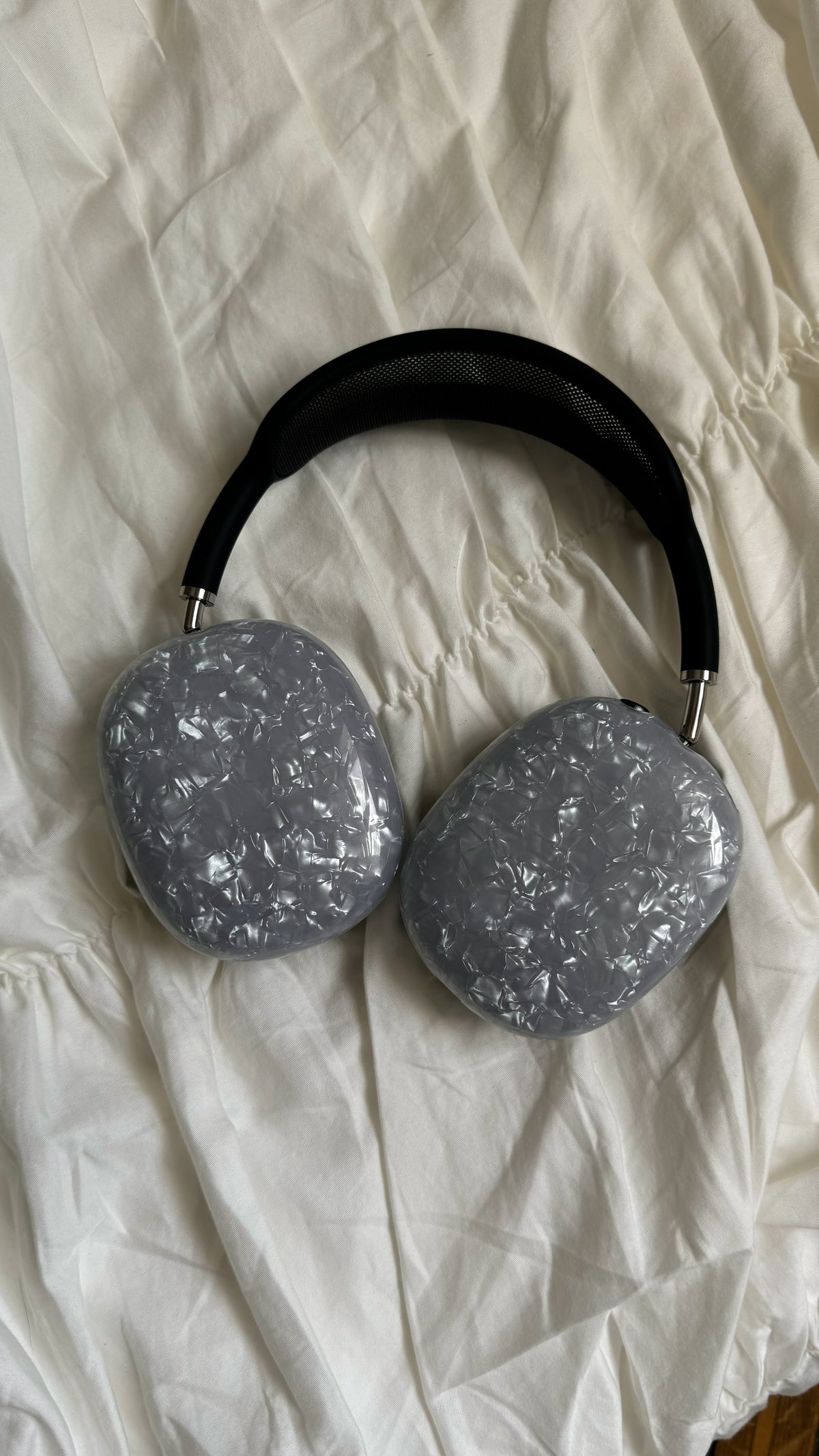 Накладки «Кришталеве сяйво» на AirPods Max — вигляд згори на кремовій тканині