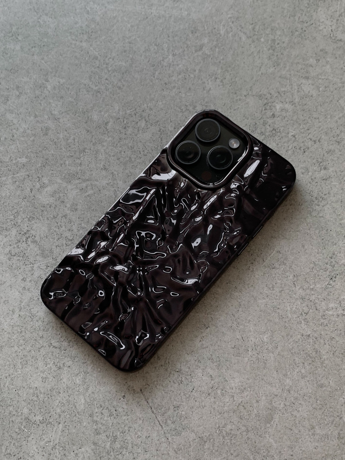 Чорний рельєфний чохол для iPhone на сірому бетоні, квадратний виріз під камеру