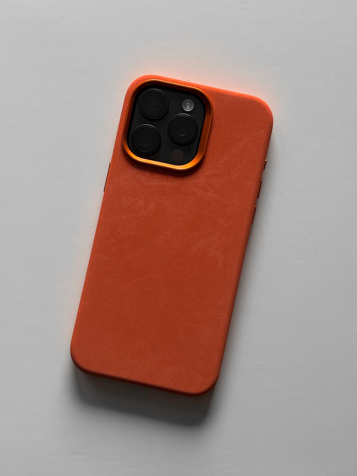 Помаранчевий чохол на iPhone з квадратним вирізом під камеру — вигляд ззаду