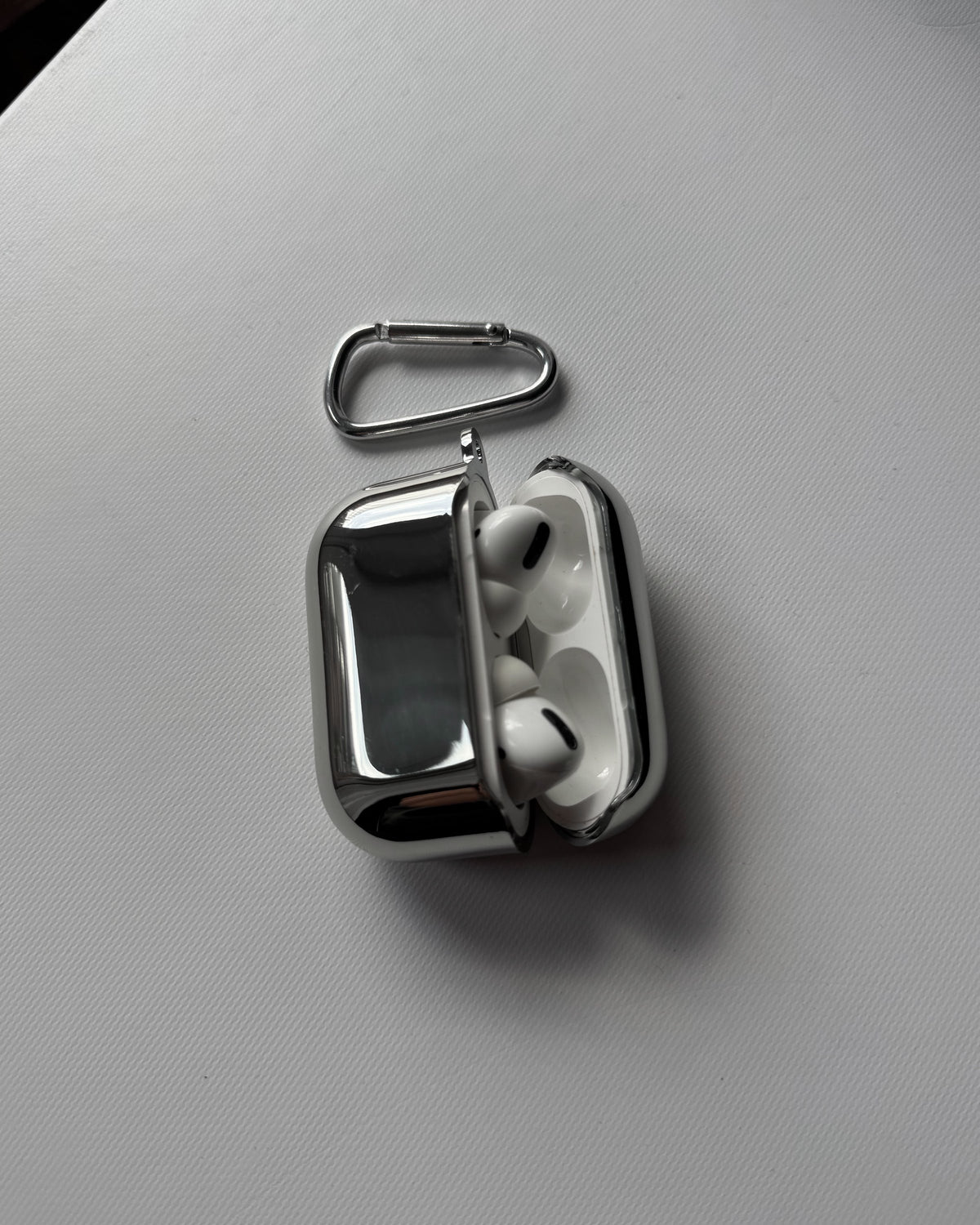 Відкритий дзеркальний чохол для AirPods з навушниками всередині та карабіном