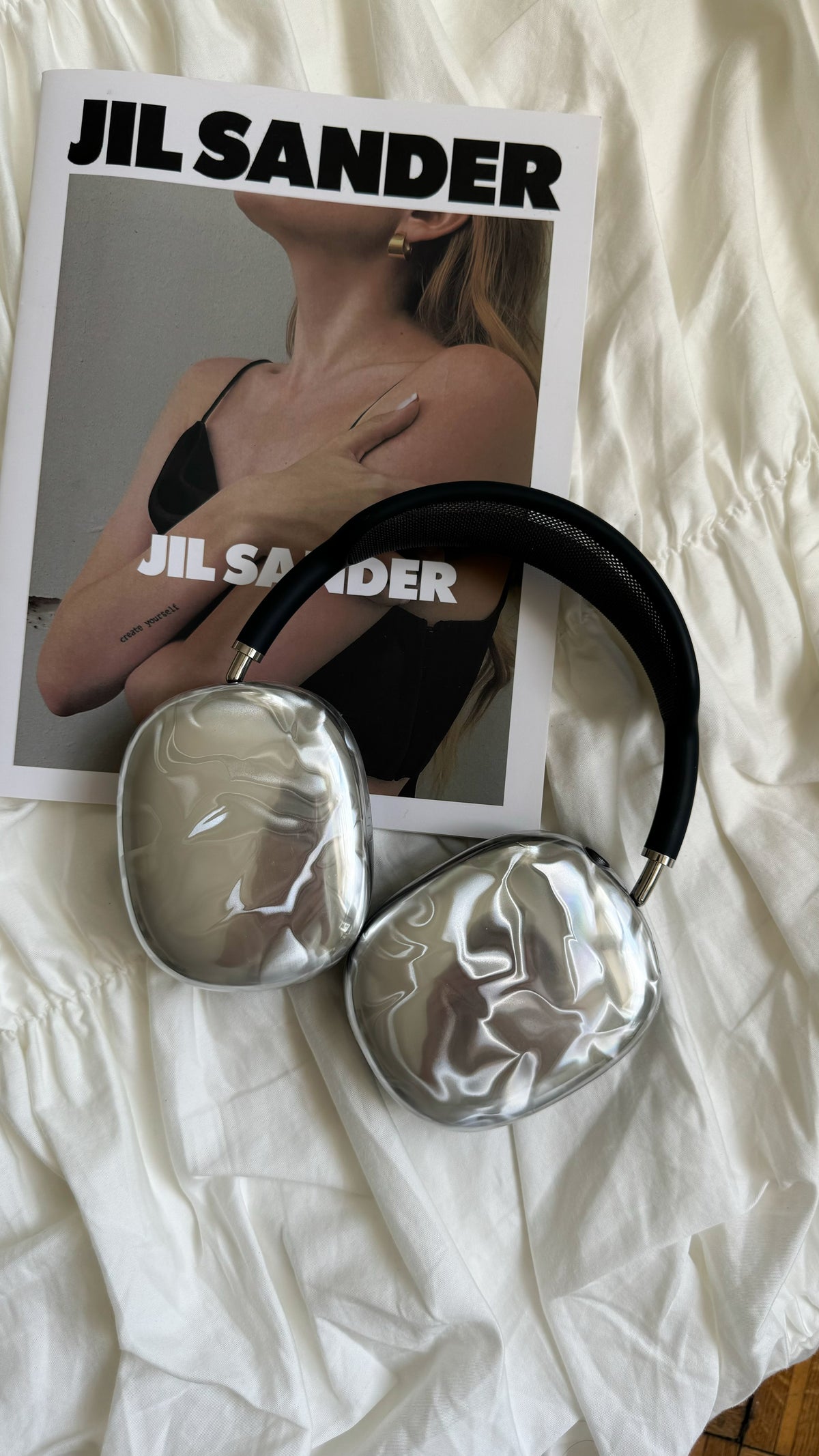 AirPods Max у сріблястих накладках на глянцевому журналі