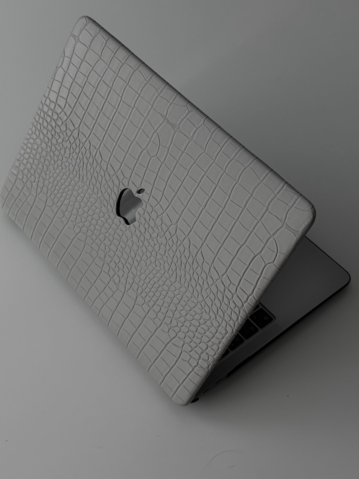 Сірий чохол Gator Skin на напіввідкритому MacBook