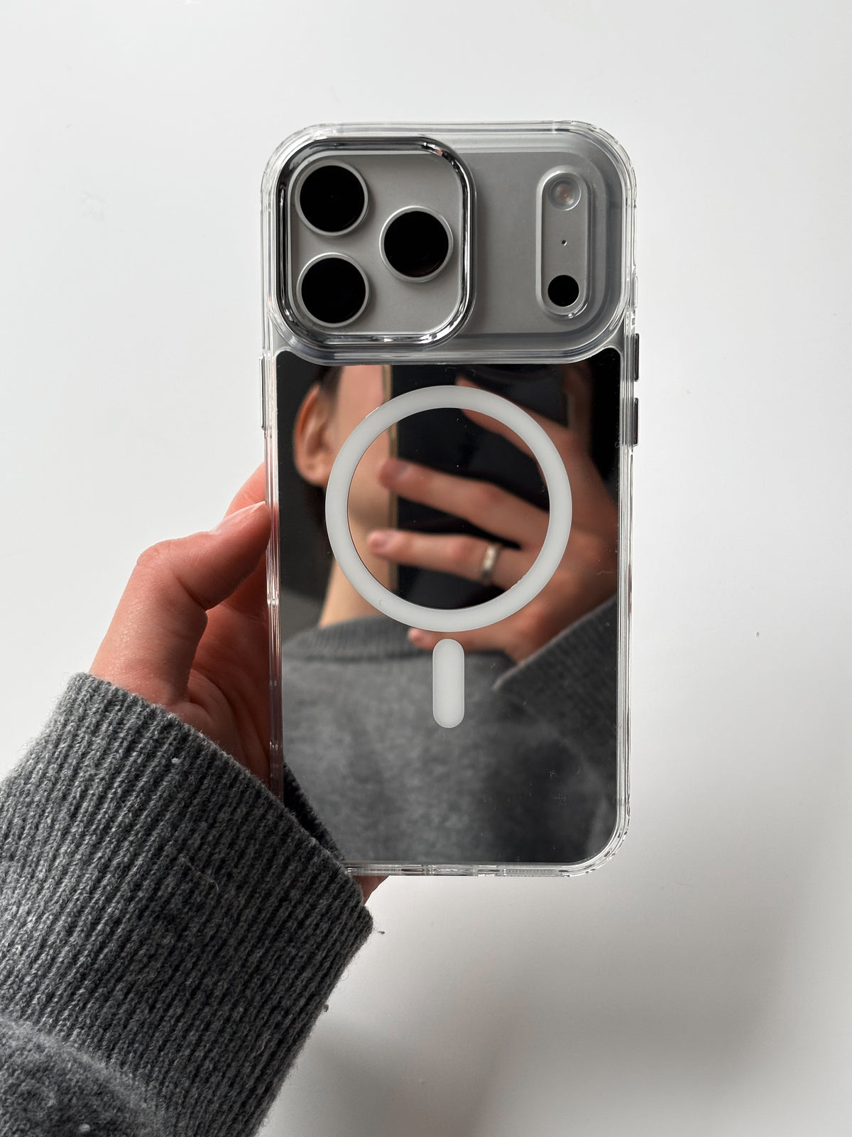 Чохол «Металеві деталі» на iPhone у руці — у задній панелі відбивається людина з телефоном