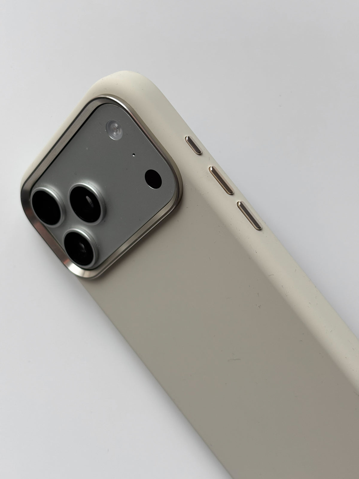 Молочний чохол для iPhone — крупний план кута з рамкою камер і кнопками