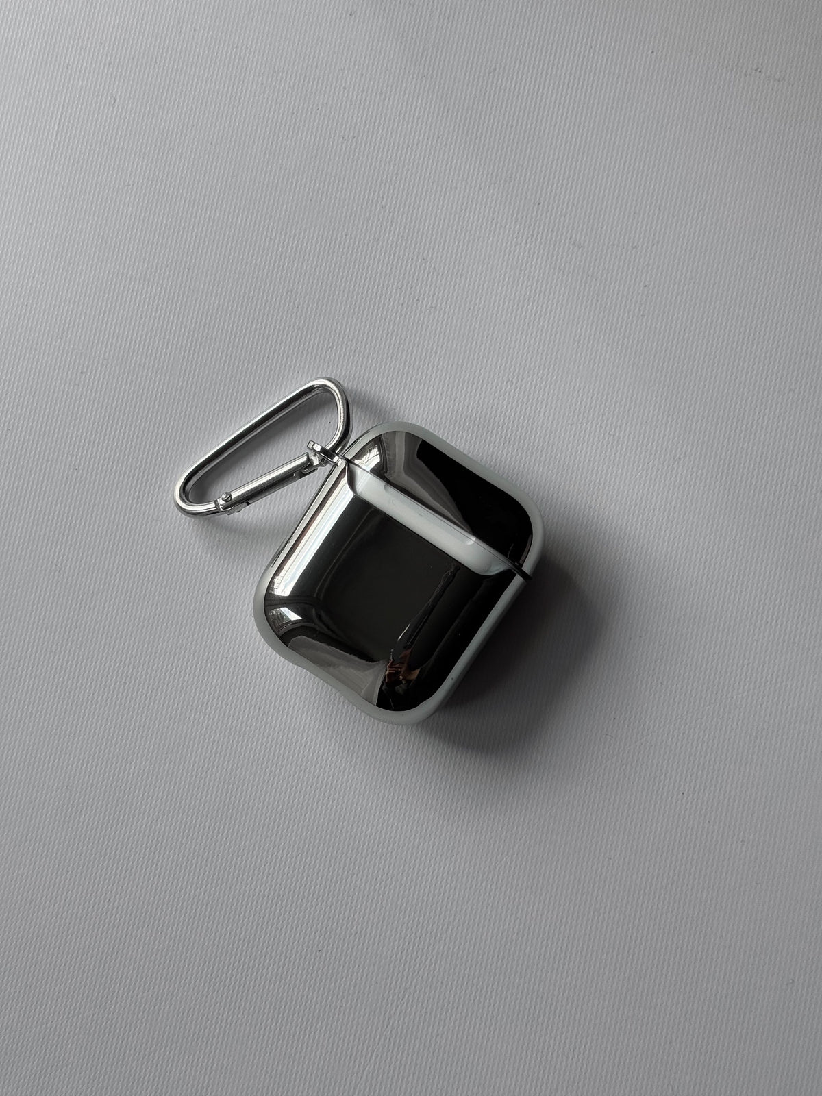 Дзеркальний чохол на вужчому кейсі AirPods із карабіном — вигляд під кутом