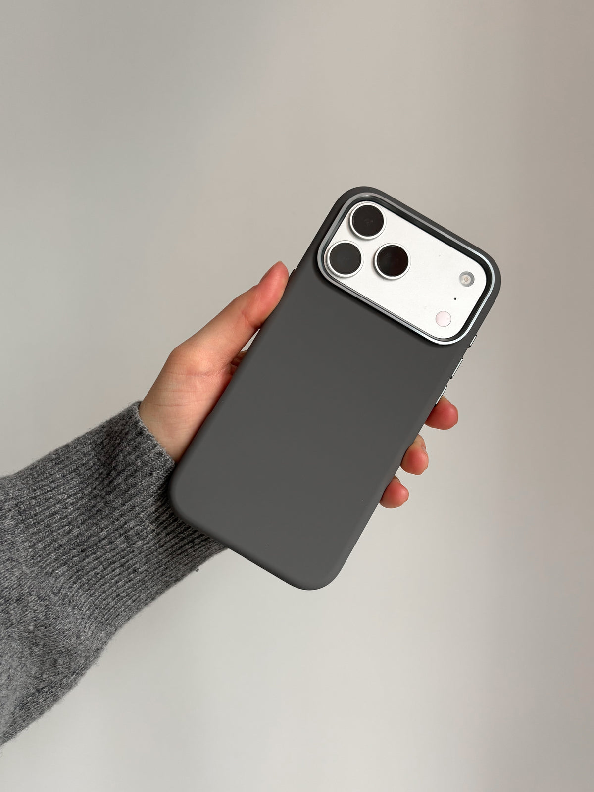 Графітовий чохол «Металеві деталі» на iPhone у руці на світлому тлі