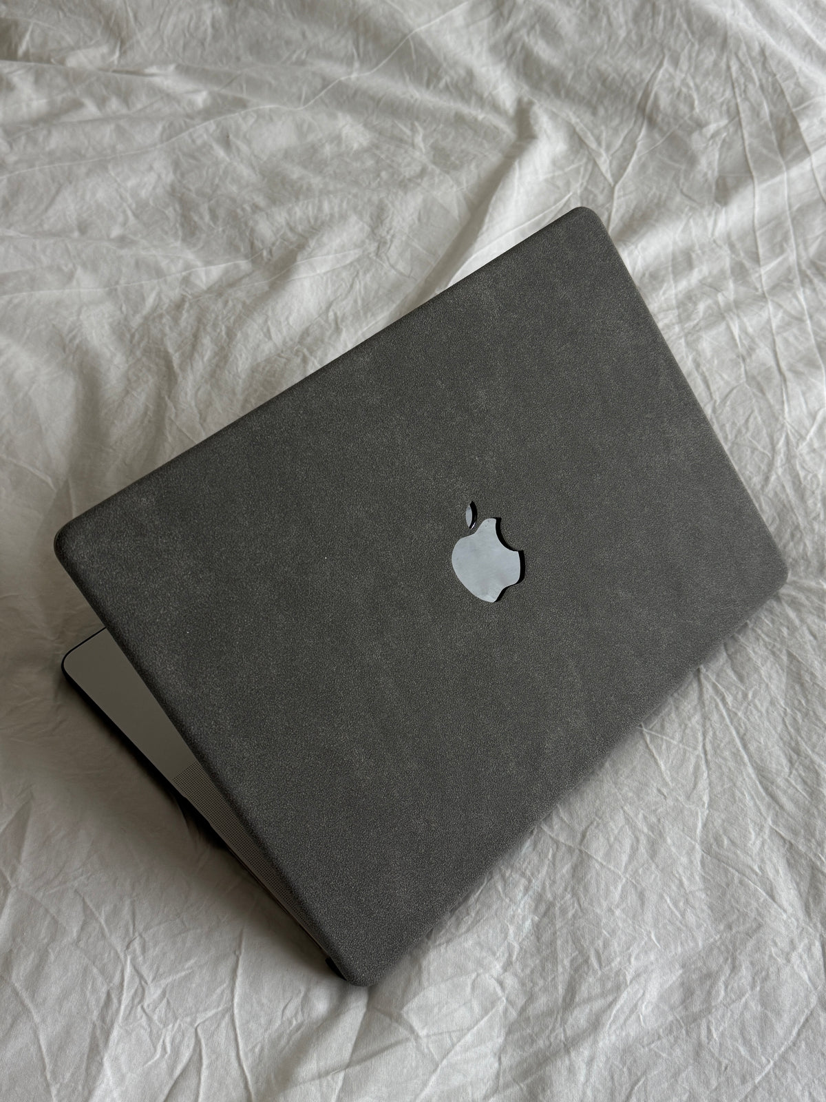 Сірий чохол-накладка «Замшева м’якість» для MacBook з м’якою ворсистою фактурою на білій постелі