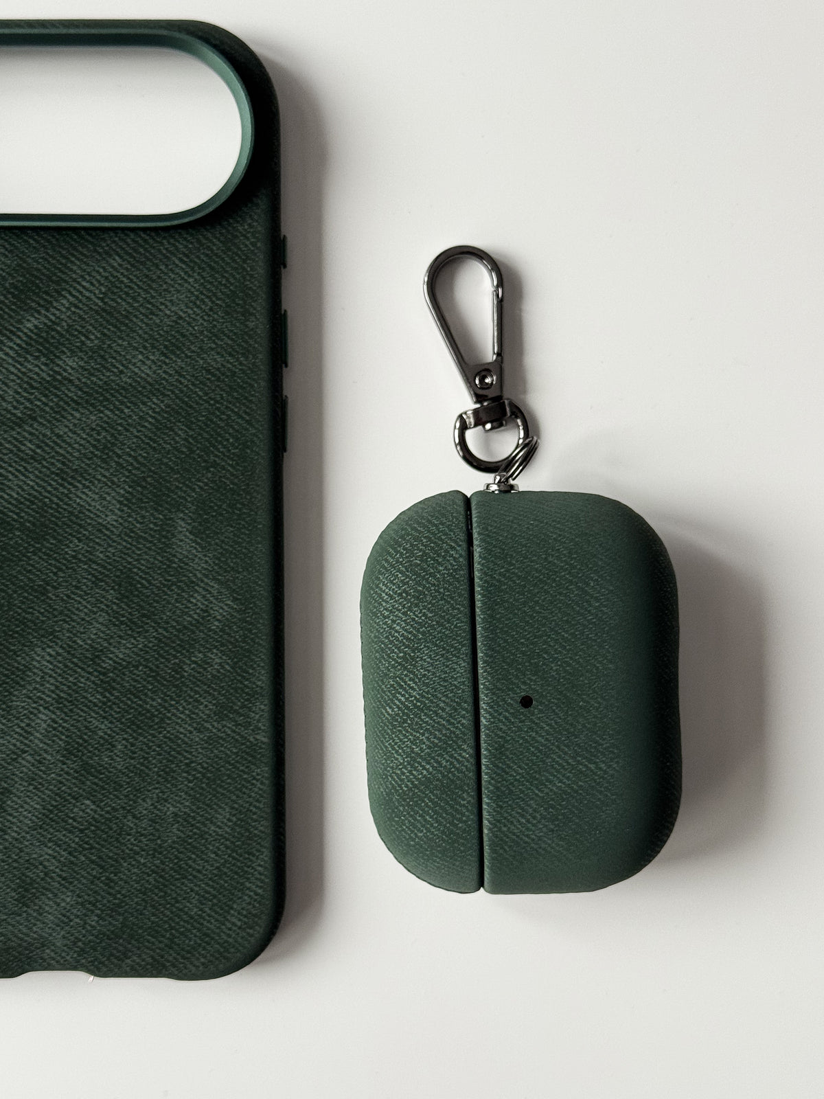 Темно-зелений чохол «Замшева м’якість» для AirPods поруч із темно-зеленим чохлом для iPhone
