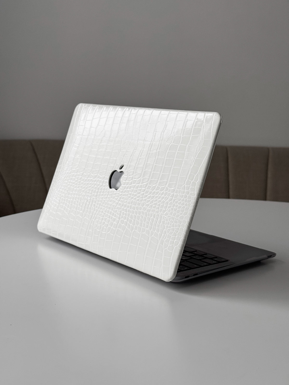 Білий чохол Gator Skin на напіввідкритому MacBook на білому столі