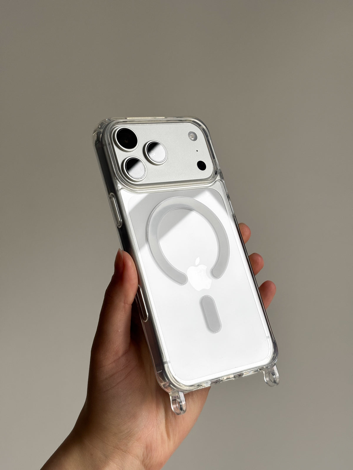 Прозорий чохол із кільцем MagSafe на світлому iPhone у руці