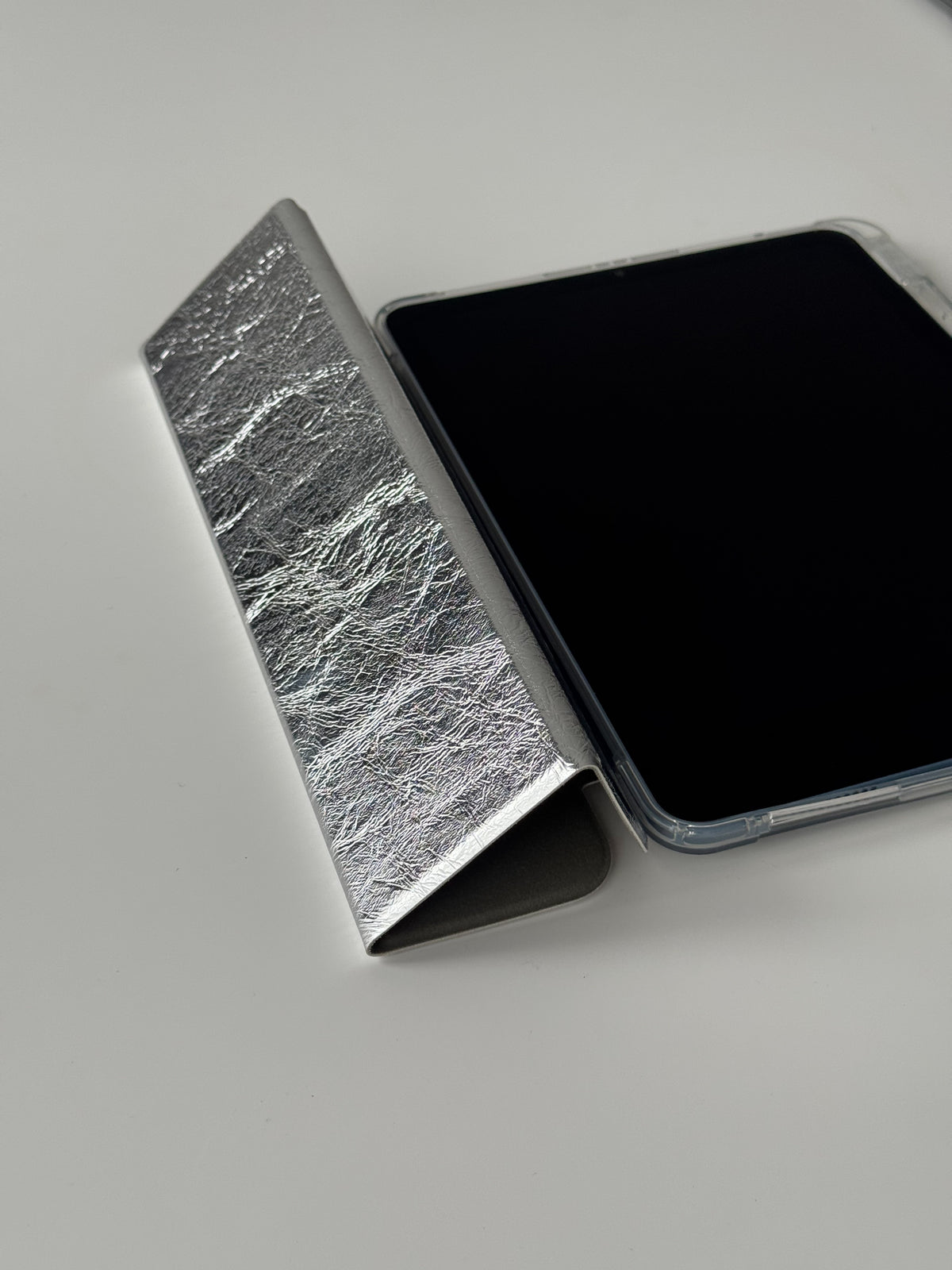 Сріблястий чохол «Текстурне сяйво» з відкинутою обкладинкою поруч з iPad