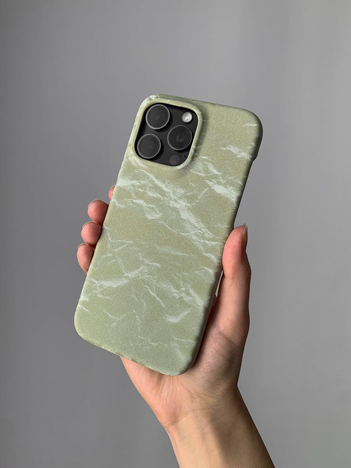 Оливковий чохол «Оксамит» на iPhone з квадратним вирізом під камеру в руці