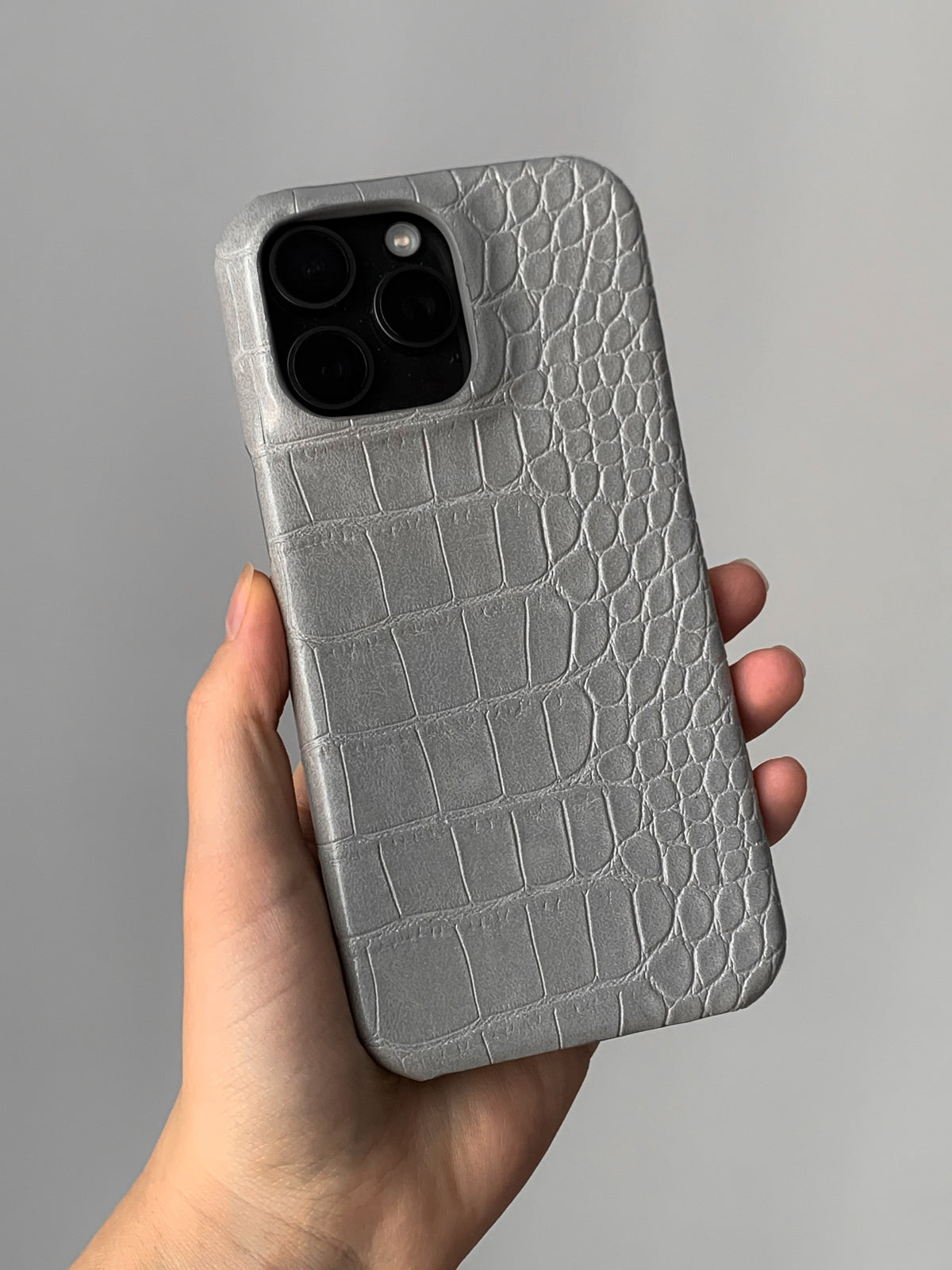 Сірий чохол Gator Skin на iPhone у руці, квадратний виріз під камеру