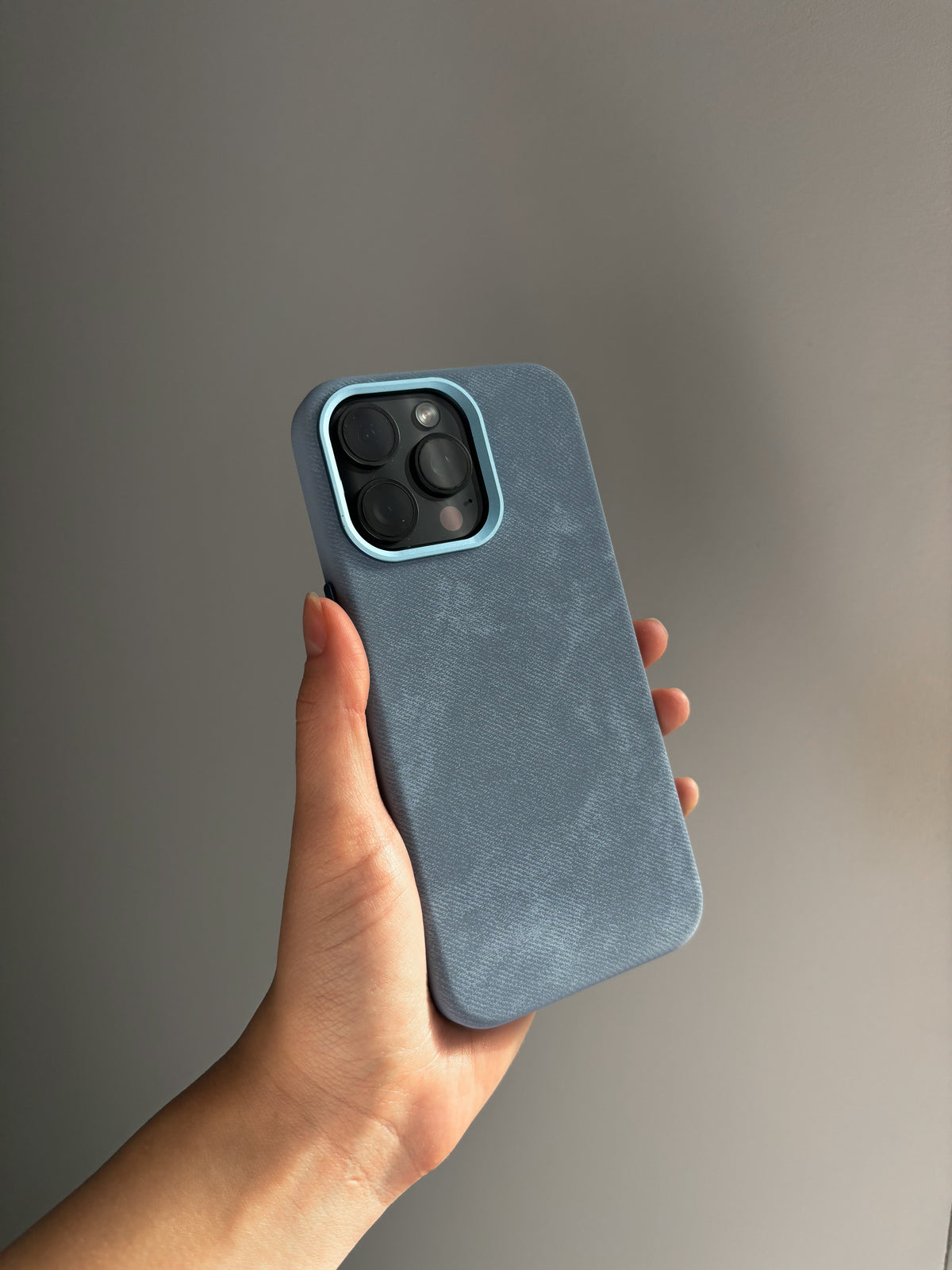 Блакитний чохол «Замшева м’якість» на iPhone з квадратним вирізом під камеру в руці