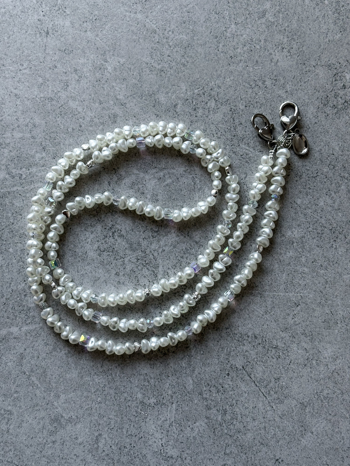 Довгий ланцюжок Crystal Pearl на сірому бетоні