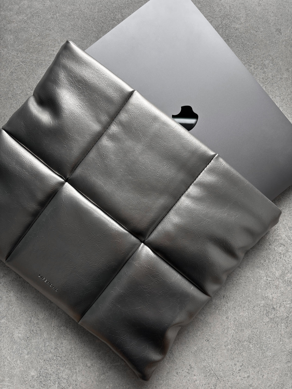 Сріблястий конверт Pillow із MacBook усередині — діагональний ракурс