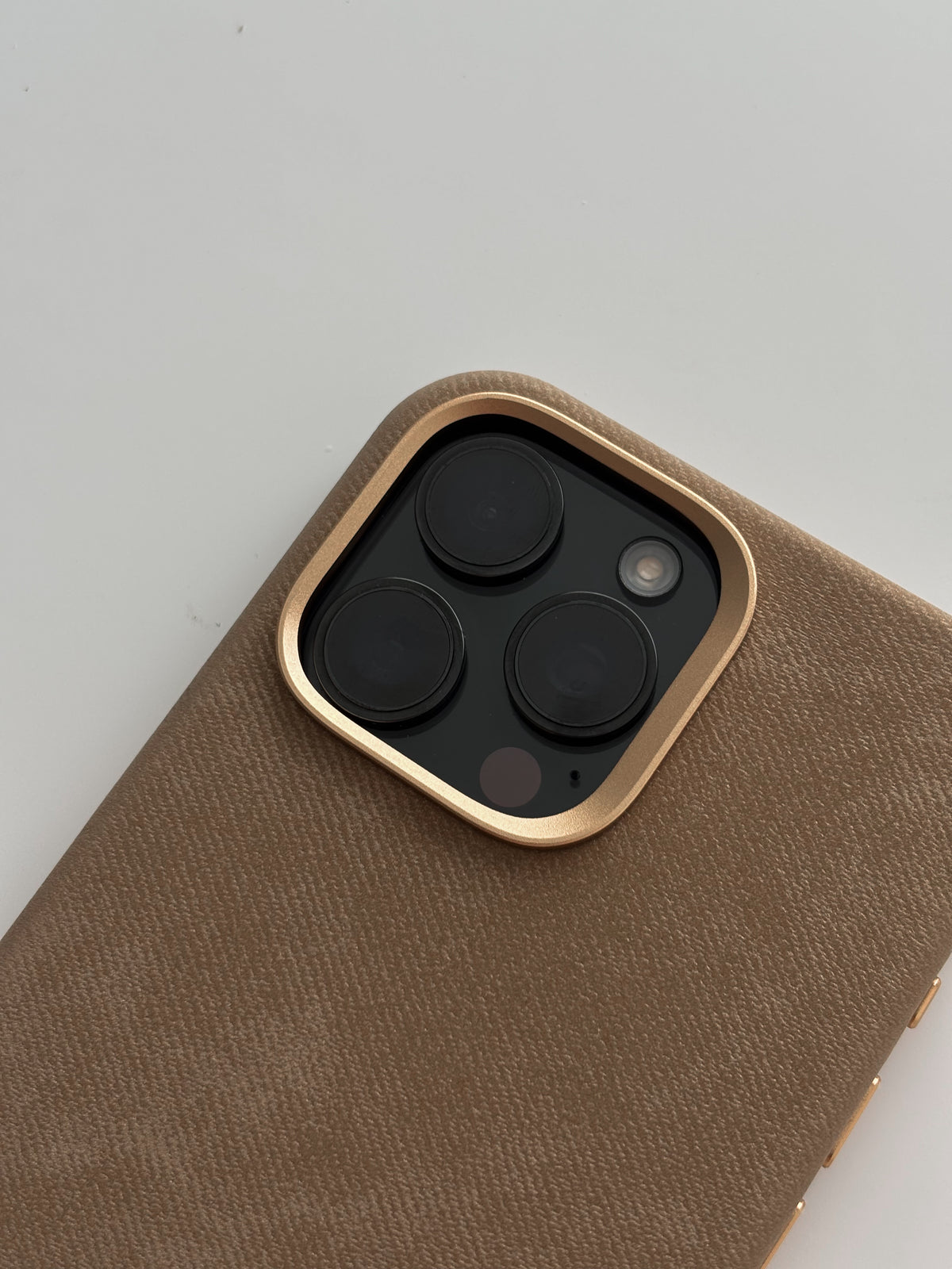 Карамельний чохол для iPhone — крупний план золотистої рамки навколо камер