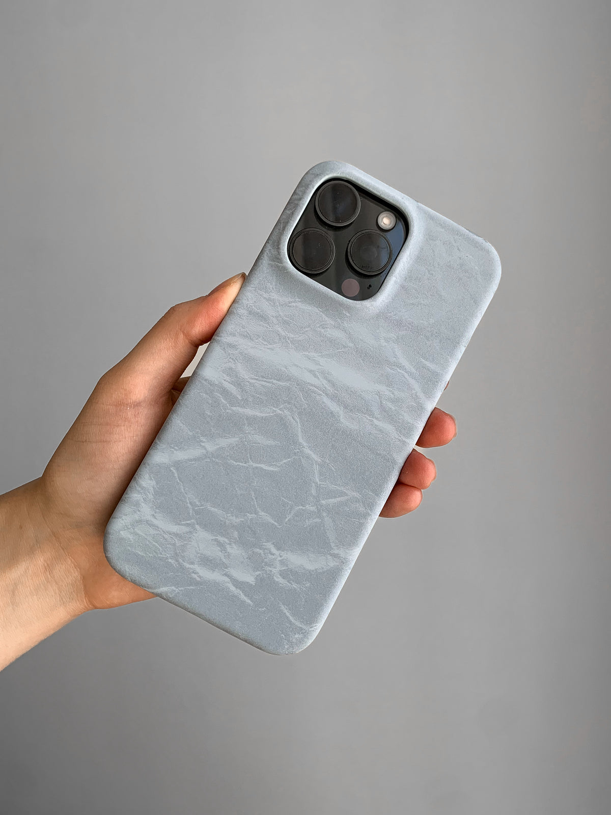 Блакитний чохол «Оксамит» на iPhone з квадратним вирізом під камеру в руці