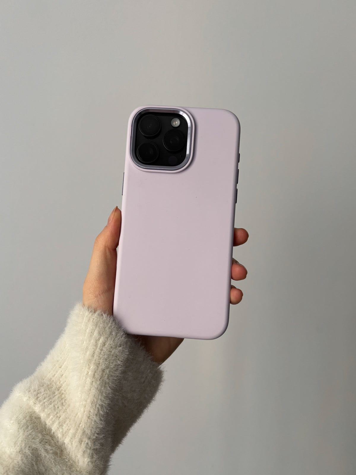 Лавандово-рожевий чохол «Металеві деталі» на iPhone у руці, квадратний виріз під камеру