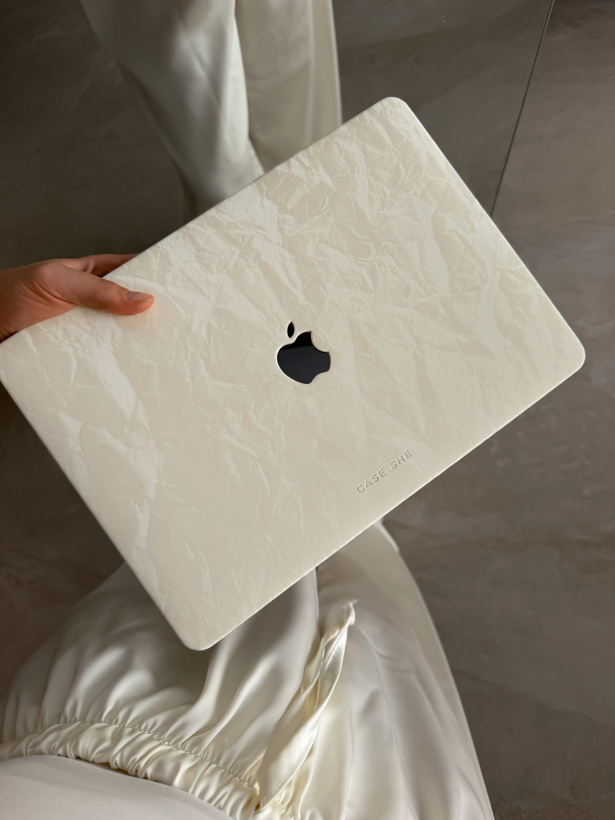 Молочний чохол-накладка «Оксамит» для MacBook із фактурою заломів у руці на тлі шовкової тканини