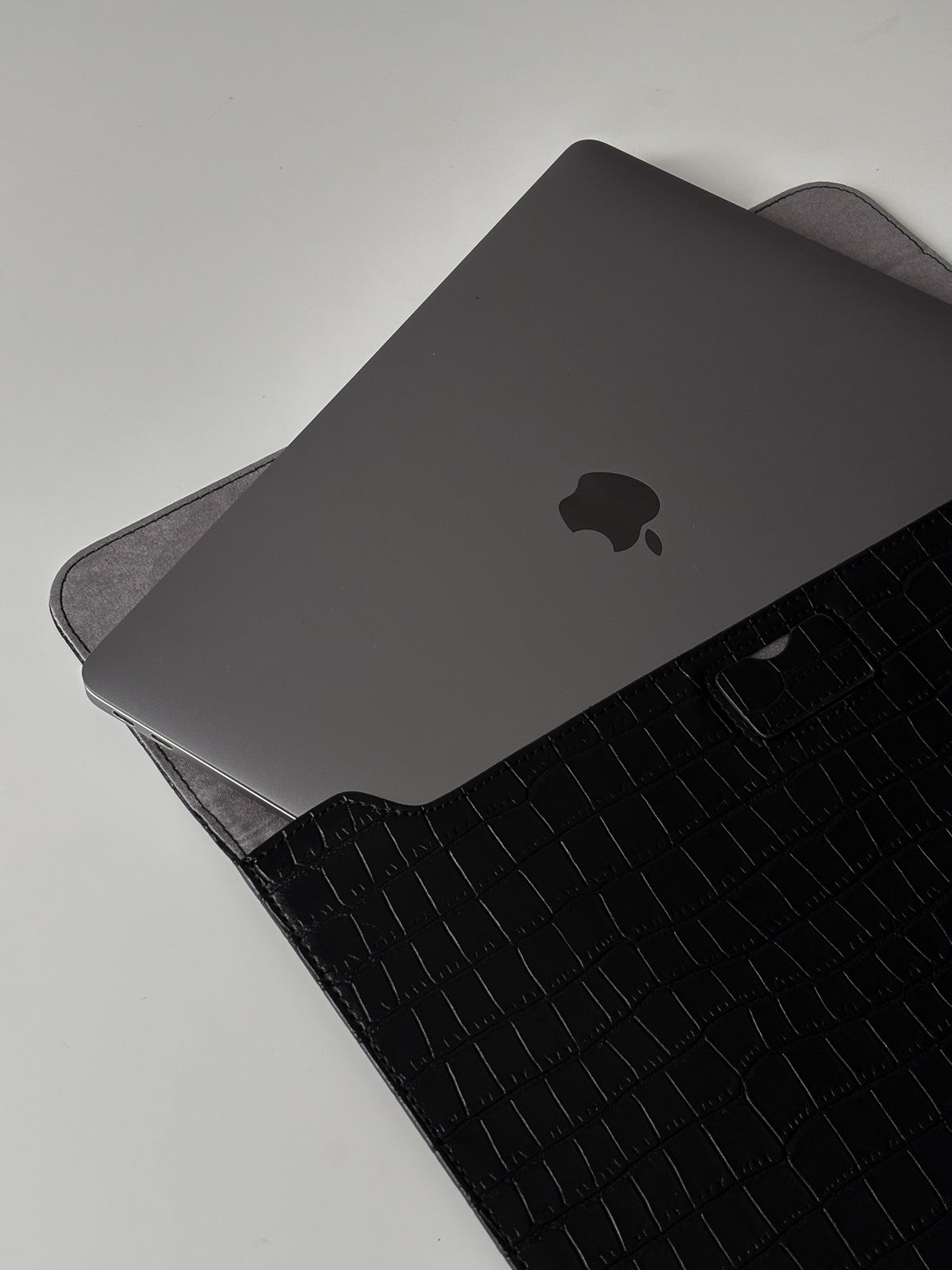 Чорний конверт Gator Skin із MacBook усередині — видно сіру підкладку