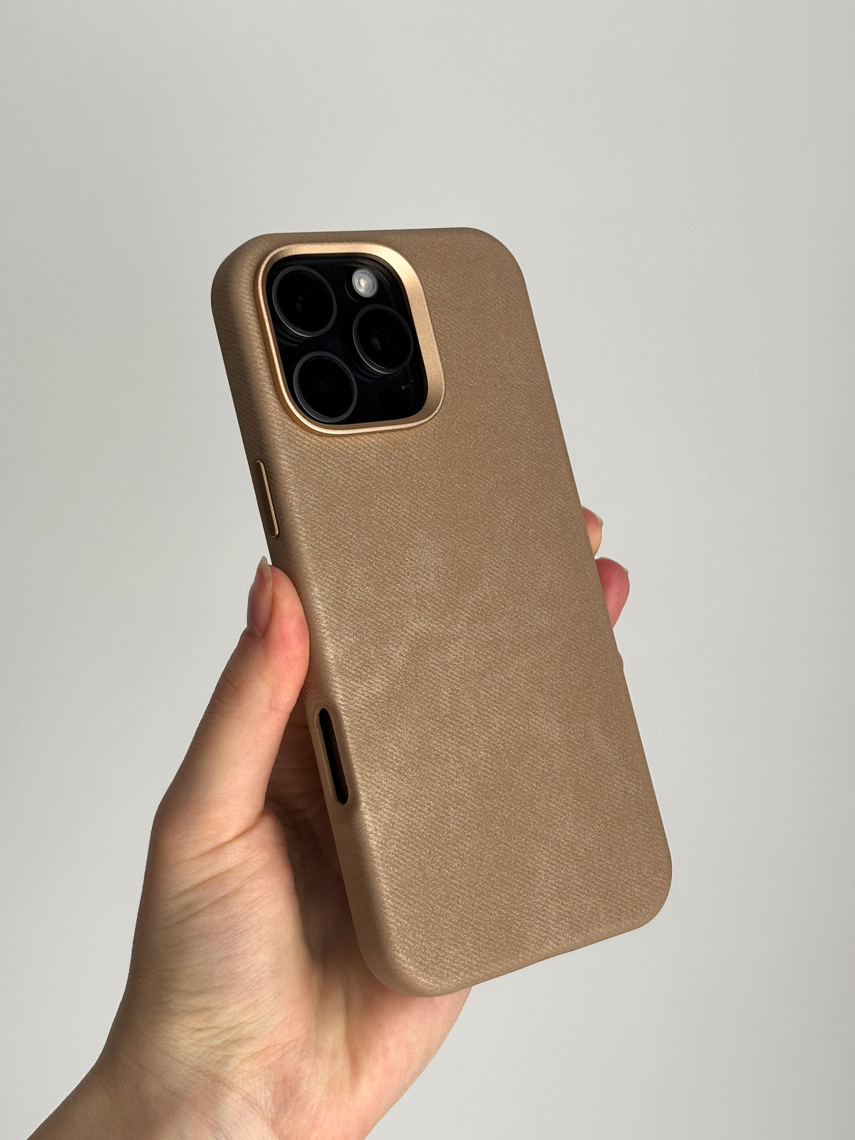 Карамельний чохол «Замшева м’якість» на iPhone у руці на світлому тлі