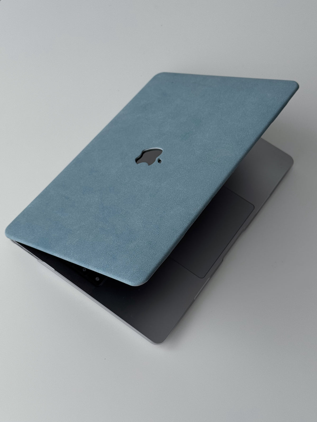 Блакитний чохол «Замшева м’якість» на напіввідкритому MacBook — вигляд згори під кутом