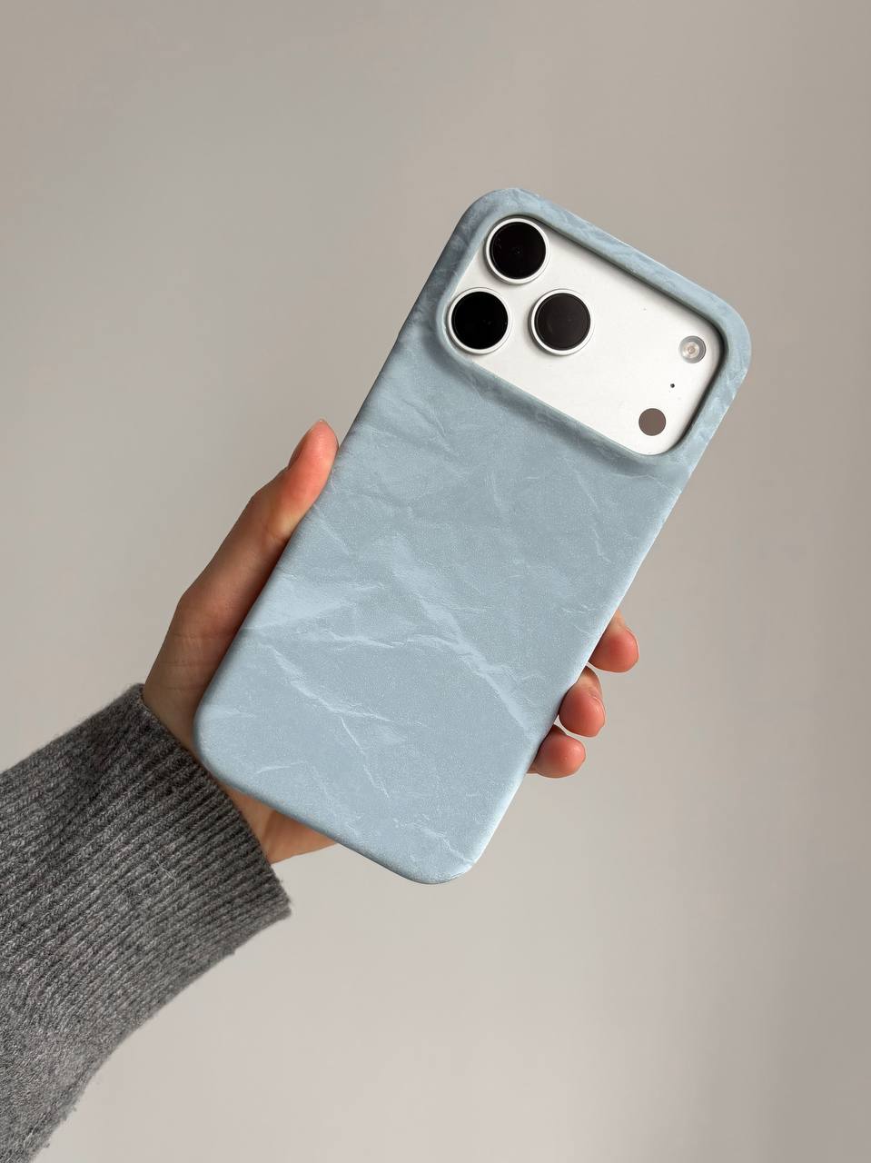 Блакитний чохол «Оксамит» на iPhone у руці в сірому рукаві