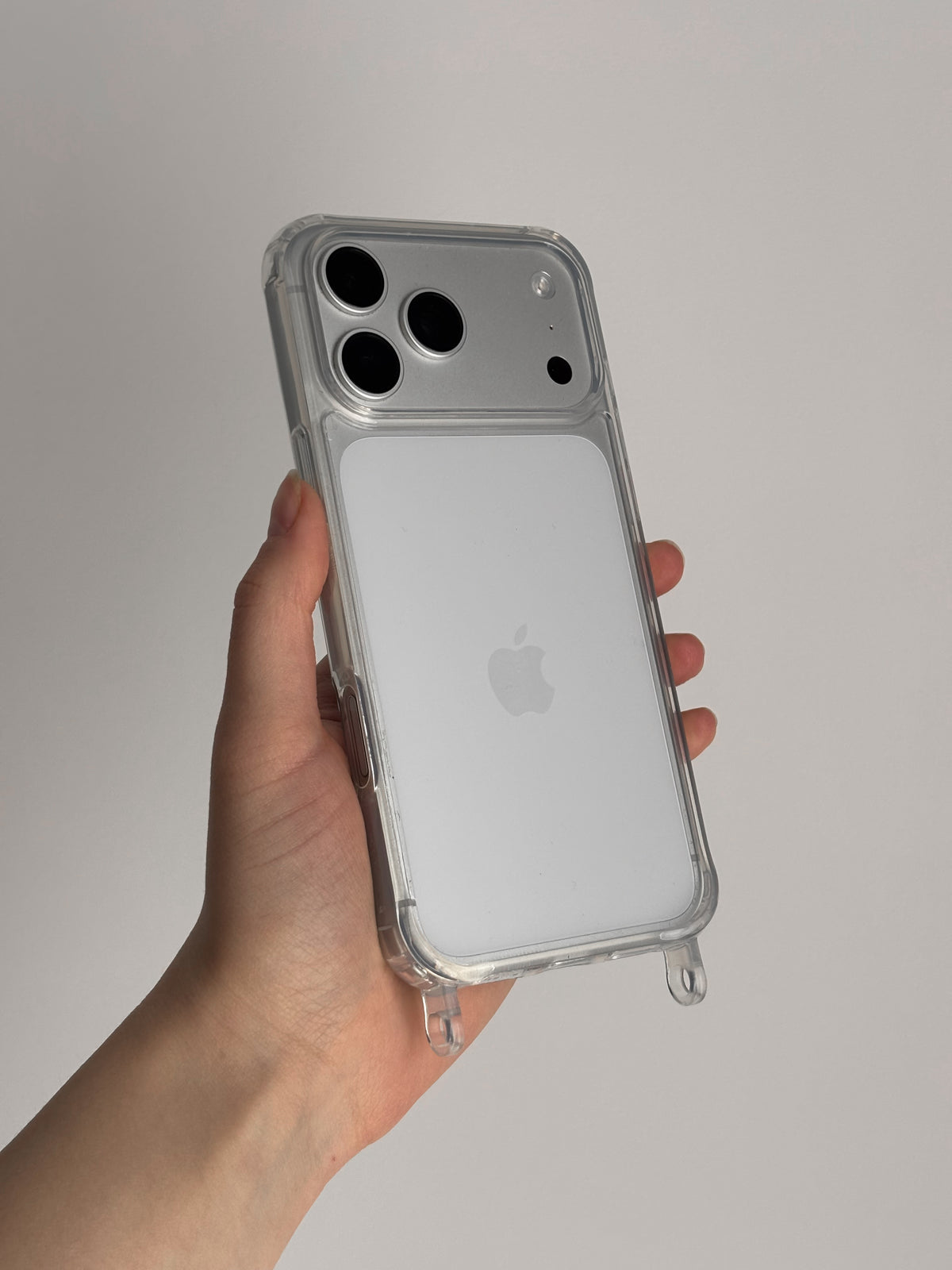 Прозорий чохол із прозорими петлями на світлому iPhone у руці