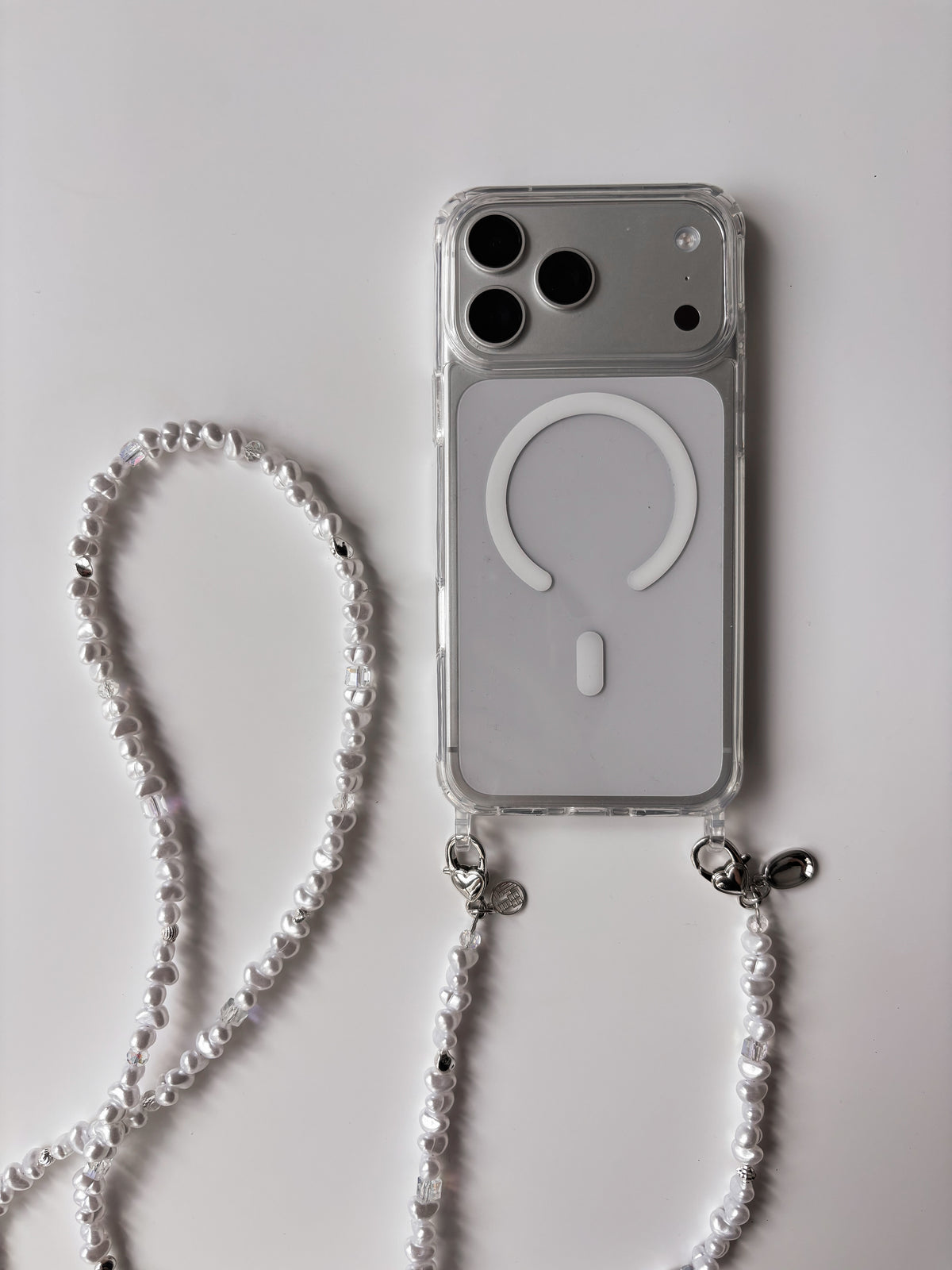Довгий ланцюжок Crystal Pearl, пристебнутий до прозорого чохла для iPhone
