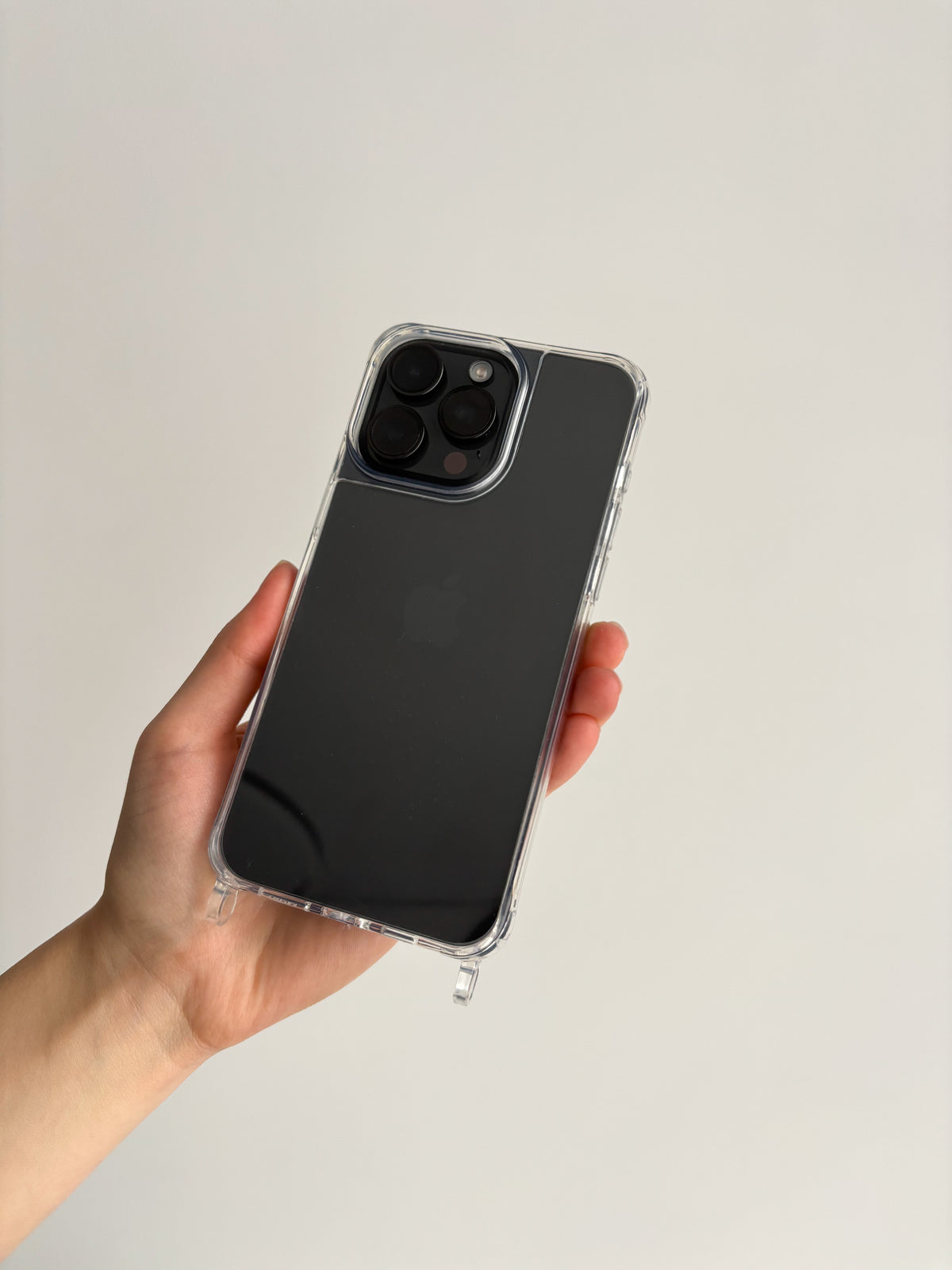 Прозорий чохол із прозорими петлями на темному iPhone у руці