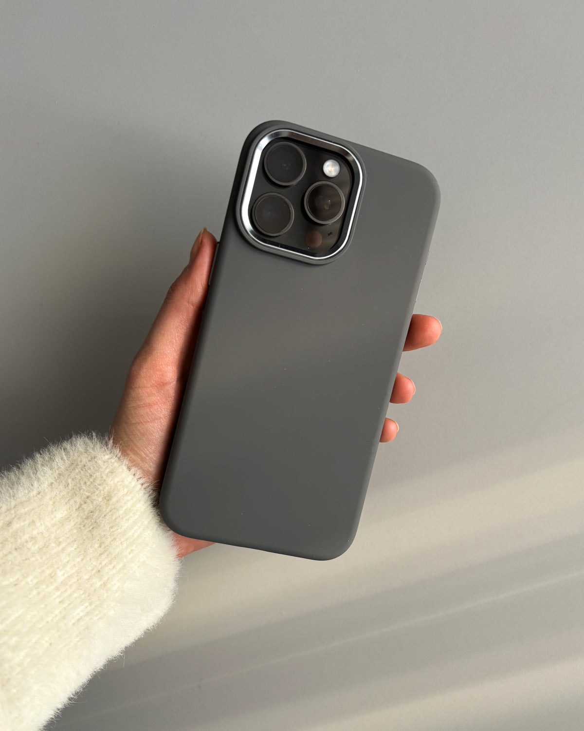 Графітовий чохол «Металеві деталі» на iPhone у руці, квадратний виріз під камеру