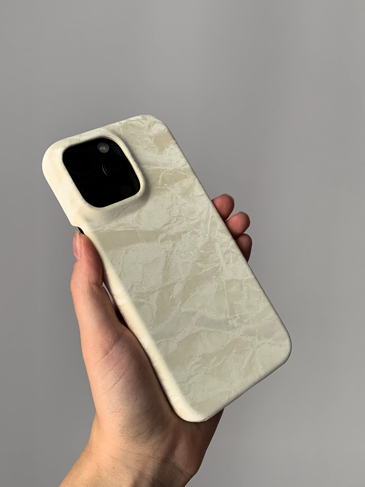 Молочний чохол «Оксамит» на iPhone з квадратним вирізом під камеру в руці