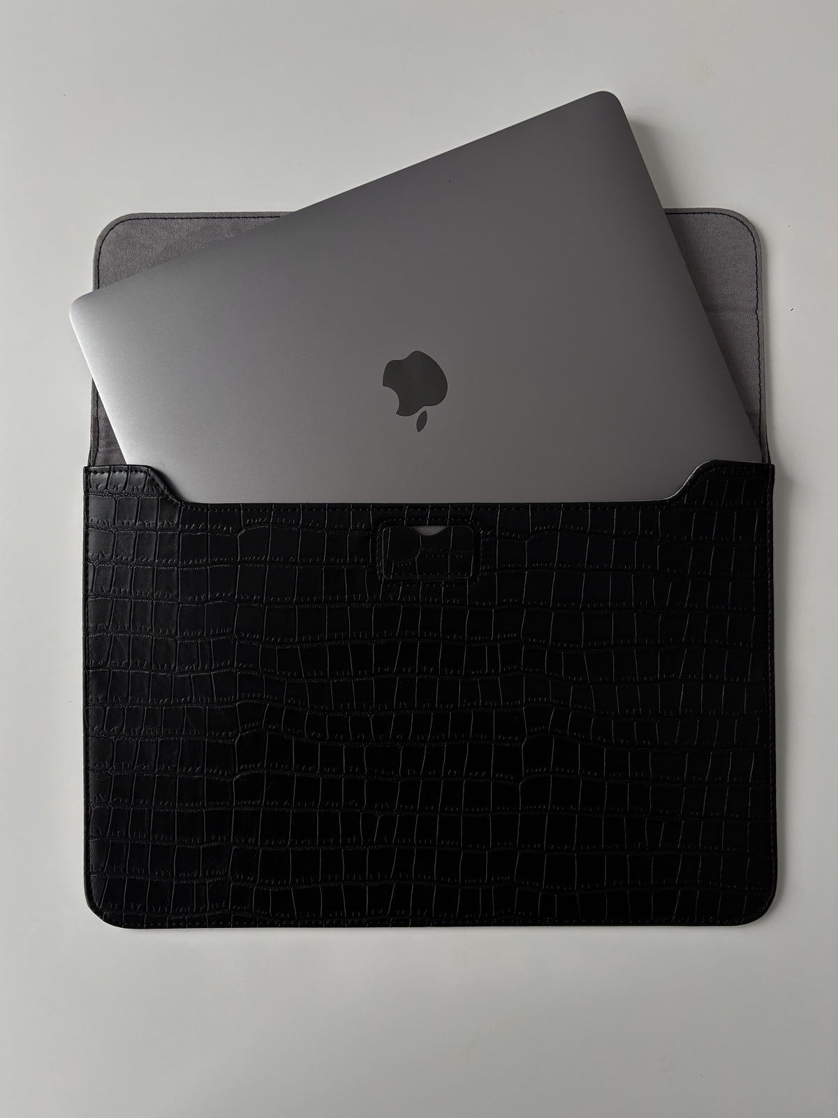Чорний конверт Gator Skin із наполовину вставленим MacBook